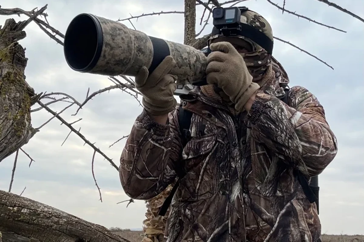 Wildlife photographer using a long telephoto lens outdoors